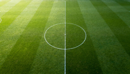Obraz premium Top down football field background, aerial green pitch with center circle lines, football and soccer wallpaper, stadium banner, sports poster design, wide 16:9 image with copy space