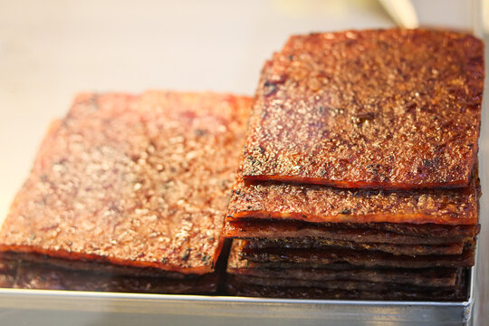 Two stacks of perfectly charred Bakkwa on display at a stall, a popular Chinese salty-sweet dried meat made from pork.