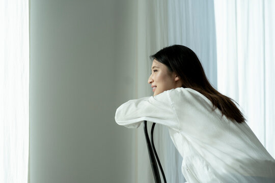 椅子の背もたれに寄りかかる若い日本人女性