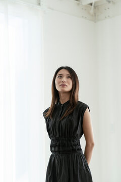 黒いワンピースを着た若い日本人女性