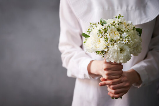 A woman holding a wedding bouquet