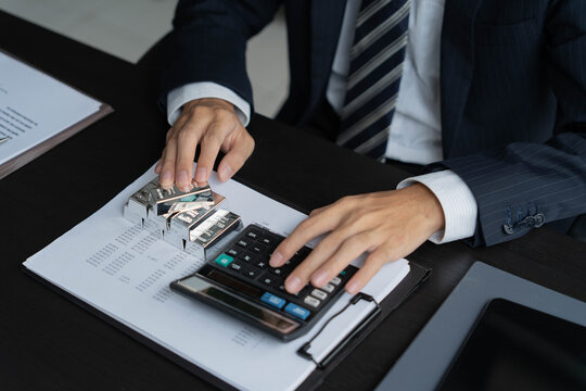 Asian businessman using calculator calculate silver price.