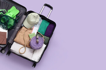 Open suitcase packed with summer travel essentials © Pixel-Shot
