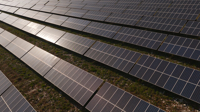 Aerial view of a large renewable energy solar panels farm with rows of photovoltaic modules installed on the ground in Portugal.