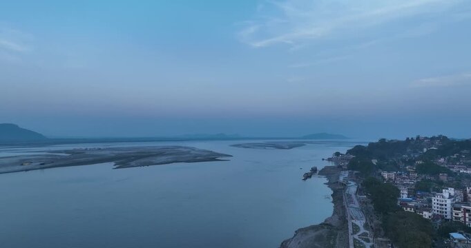 A stunning panning drone shot of Guwahati city with the glowing Brahmaputra River beneath a golden sunset&mdash;serene, majestic, and breathtakingly cinematic in every frame. 4K