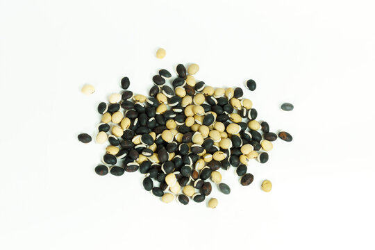 A pile of mixed raw black and white beans, including black gram, urad dal, and mung beans, isolated on white background