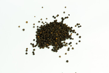 Naklejka premium A pile of whole black peppercorns scattered on a white background, isolated on white background