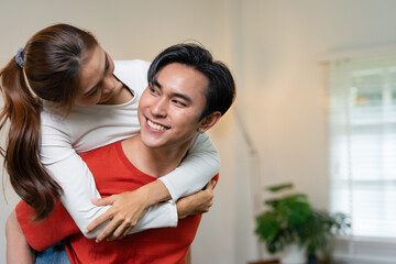 Fototapeta premium Couple, people and smile in home with piggyback to relax for bonding, love and support together.