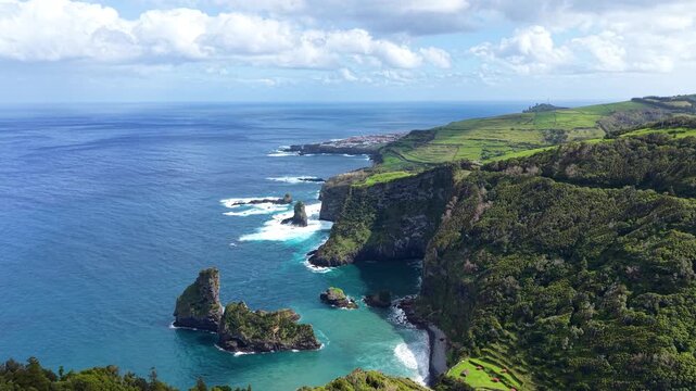 Spectacular drone panorama showcasing rugged volcanic cliffs emerald forests turquoise coves and iconic sea stacks along the coast of Flores Island Azores Portugal