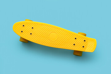 Yellow skateboard on blue background, top view © Pixel-Shot