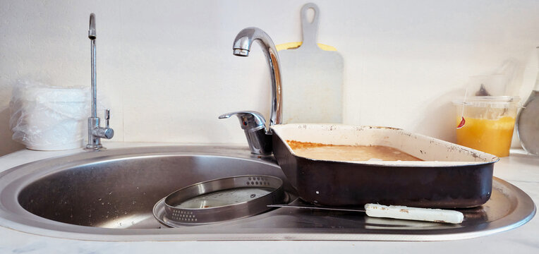 A dirty baking sheet sits by the sink after baking&mdash;life as it is.