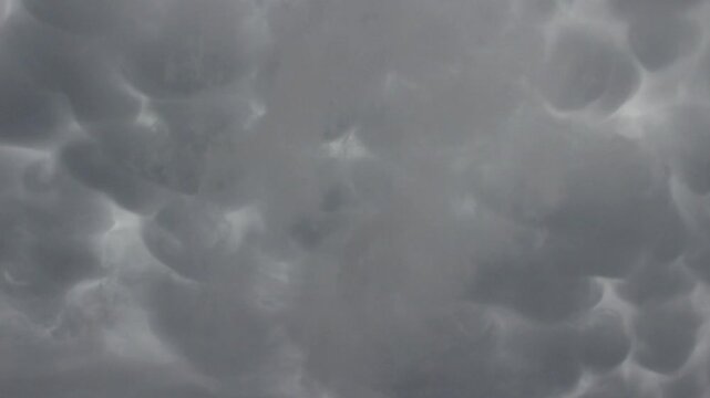 Mammatus clouds and scud clouds drift across the sky overhead in this time lapse footage.