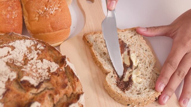 Spreading Chocolate and Peanut Butter on Fresh Multigrain Bread Slice