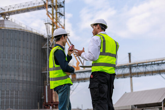 Engineers discussing project at industrial grain elevator site