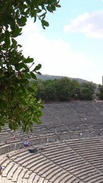 Ancient Theatre of Epidaurus revealing from behind trees