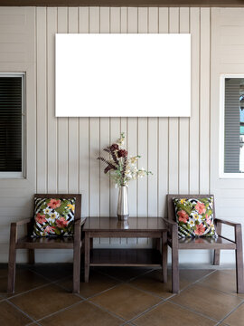 White blank frame mockup hanging on living room wall above wooden furniture. Modern interior design with copy space for artwork, poster, branding, advertising, home decor, and gallery display.
