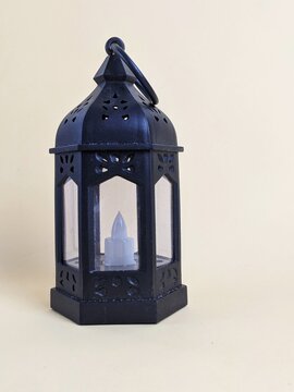 lantern with candle. Black hexagonal lantern with LED candle, decorative cutouts, and glass panels, designed for ambient lighting and ornamental display.