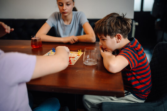Children playing board game together at home