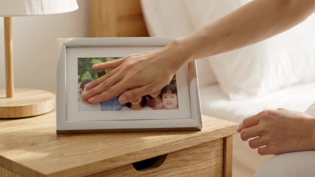 Happy family portrait vdo frame on wooden bedroom table with smiling parents children and hand holding cozy home decor frame