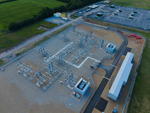 Aerial view of the Biggleswade National Grid 400132kV Substation with electrical infrastructure and switchgear on a gravel site in Biggleswade, England, United Kingdom.