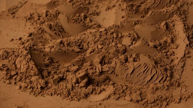 Rotating brown cocoa powder background for culinary video projects.