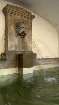 Historic Stone Wall Fountain Spouting Water in Czechia.