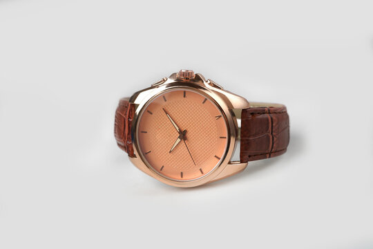 Luxury rose gold men wrist watch with brown leather strap isolated on white background.