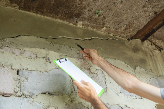 Man checking a cracked wall after earthquake.