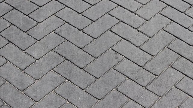 Slow Left to Right Pan Across Grey Herringbone Brick Paving Texture