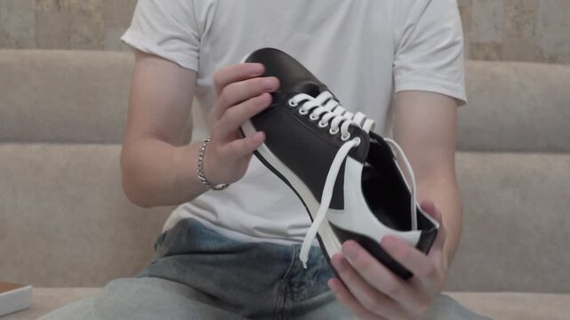 Demonstration of design of new leather sneakers, Shopper inspecting new shoes after unpacking at home