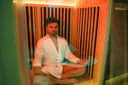 Man entering infrared sauna room at a luxury gym, embracing modern recovery, detoxification, biohacking, longevity, and mindful wellness practices in a modern fitness and spa environment