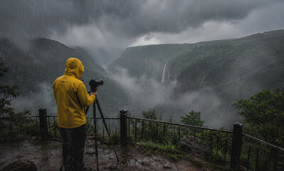 Naklejka premium Photographer Capturing Meghalaya Monsoon Landscape from Scenic Viewpoint