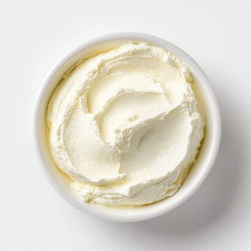 Minimalist still life featuring smooth cream cheese in a white bowl with bright, clean lighting