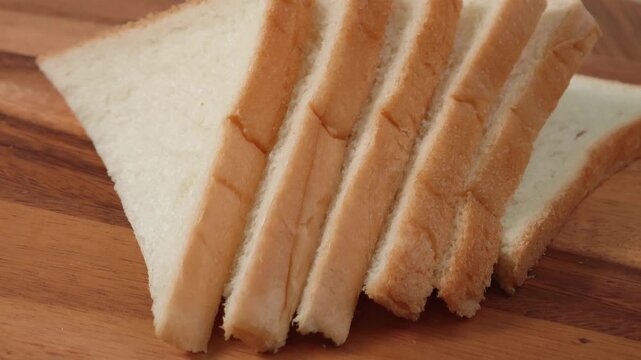 French bread slices on wooden cutting surface