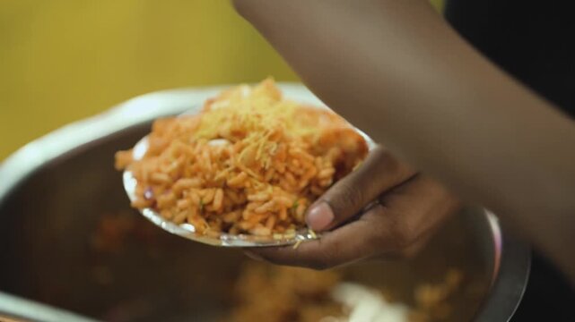 Bhel Chaat Garnished with Sev, Street Vendor Serving Bhel Chaat, Indian Street Food Preparation, Crispy Bhel Snack Close Up stock video.