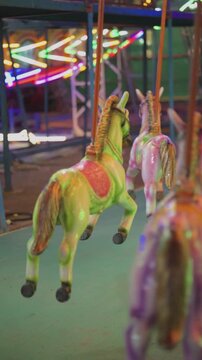 Carousel horse ride at night fair, Colorful merry go round horse closeup, Kids amusement ride in carnival lights, Mela jhula horse carousel at night stock video.