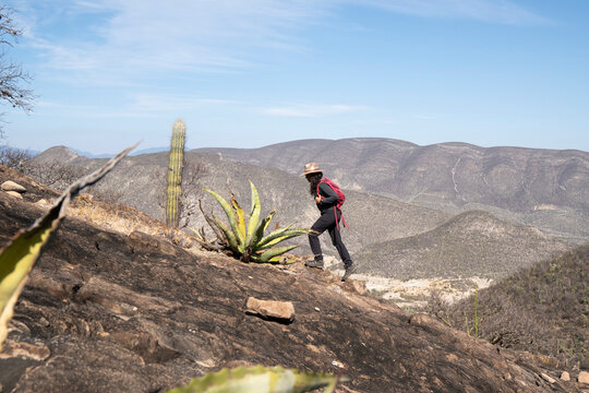 Woman hiking up a steep rocky desert hill