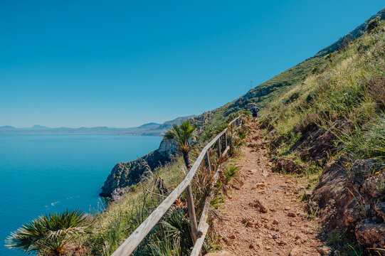 Hiker on a Coastal trail above Punta Leone in Zingaro