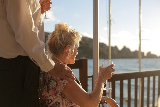 Senior couple enjoying wine on a deck at sunset