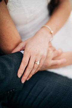 Couple holding hands with an emerald cut engagement ring