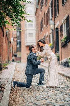 Romantic couple gets engaged on a cobblestone street