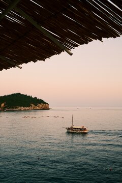 Traditional Tour Boat Sailing past a Rocky Island View