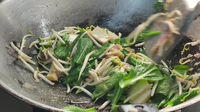 Mustard greens, bean sprouts, and fish cakes are quick-fried in a hot wok. Aromatics like onions and anchovies are added. This creates a delicious, savory meal that keeps the vegetables crisp.