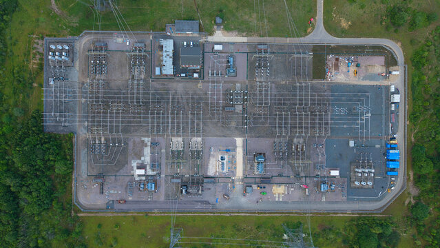 Aerial view of Wymondley Substation featuring electrical transformers, switchgear, and power lines within a fenced compound surrounded by green fields in Saint Ippolyts, England, United Kingdom.