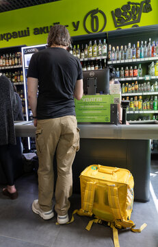 Food delivery courier purchasing alcohol in Lviv store