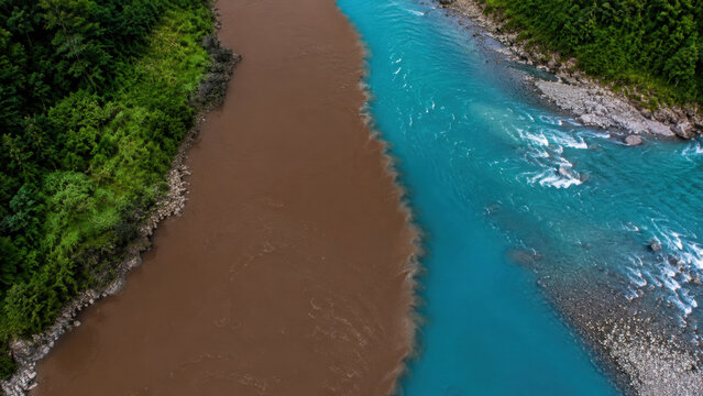 Muddy Floodwater Mixing with Turquoise Mountain River