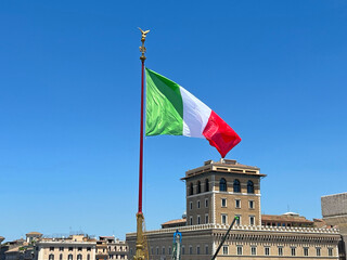 Italian flag waving on a pole against a clear blue sky. Democracy and politics. European country. For travel, culture, patriotism