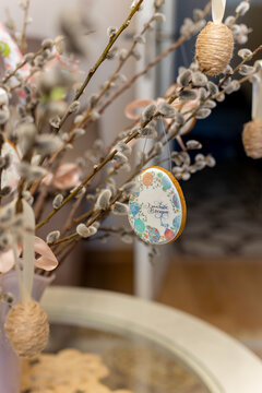Gingerbread Easter figurines an Easter egg with the words ,Happy Easter, written on it, hanging on a pussy willow branch,