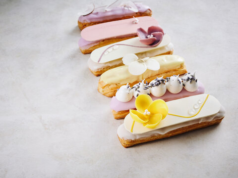Elegant eclairs with floral decorations, bakery showcase, dessert menu inspiration