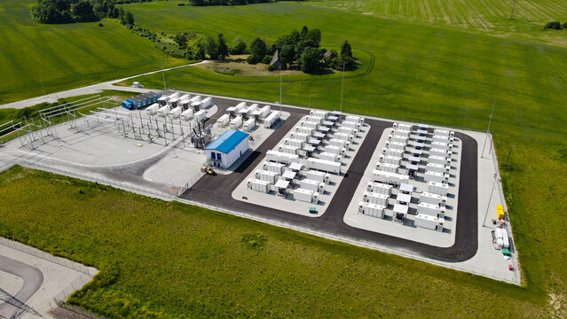 Battery energy storage system on a green field providing grid stabilization and renewable energy integration, showcasing modern infrastructure for sustainable power solutions and future energy needs
